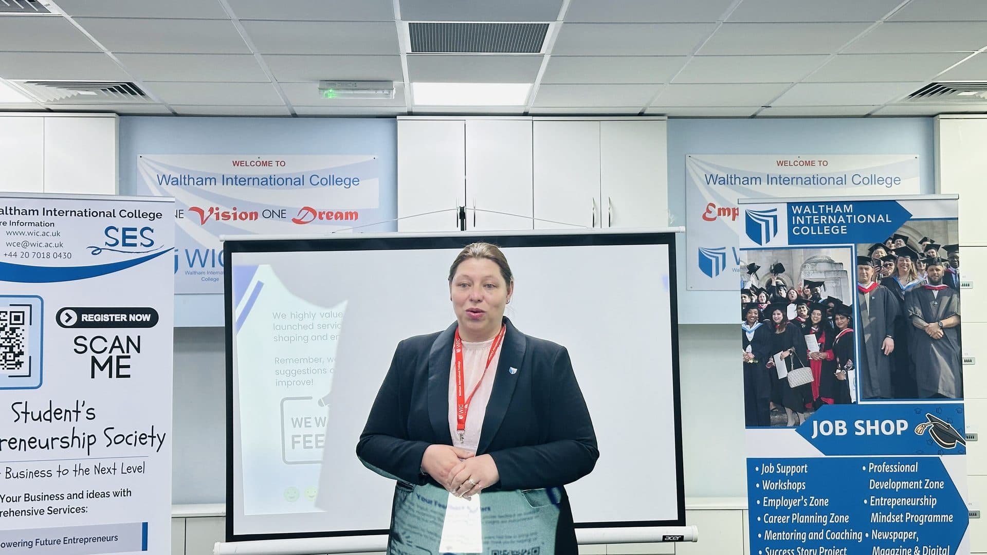 A WIC staff member speaking to the audience beside a 'Student's Entrepreneurship Society' banner