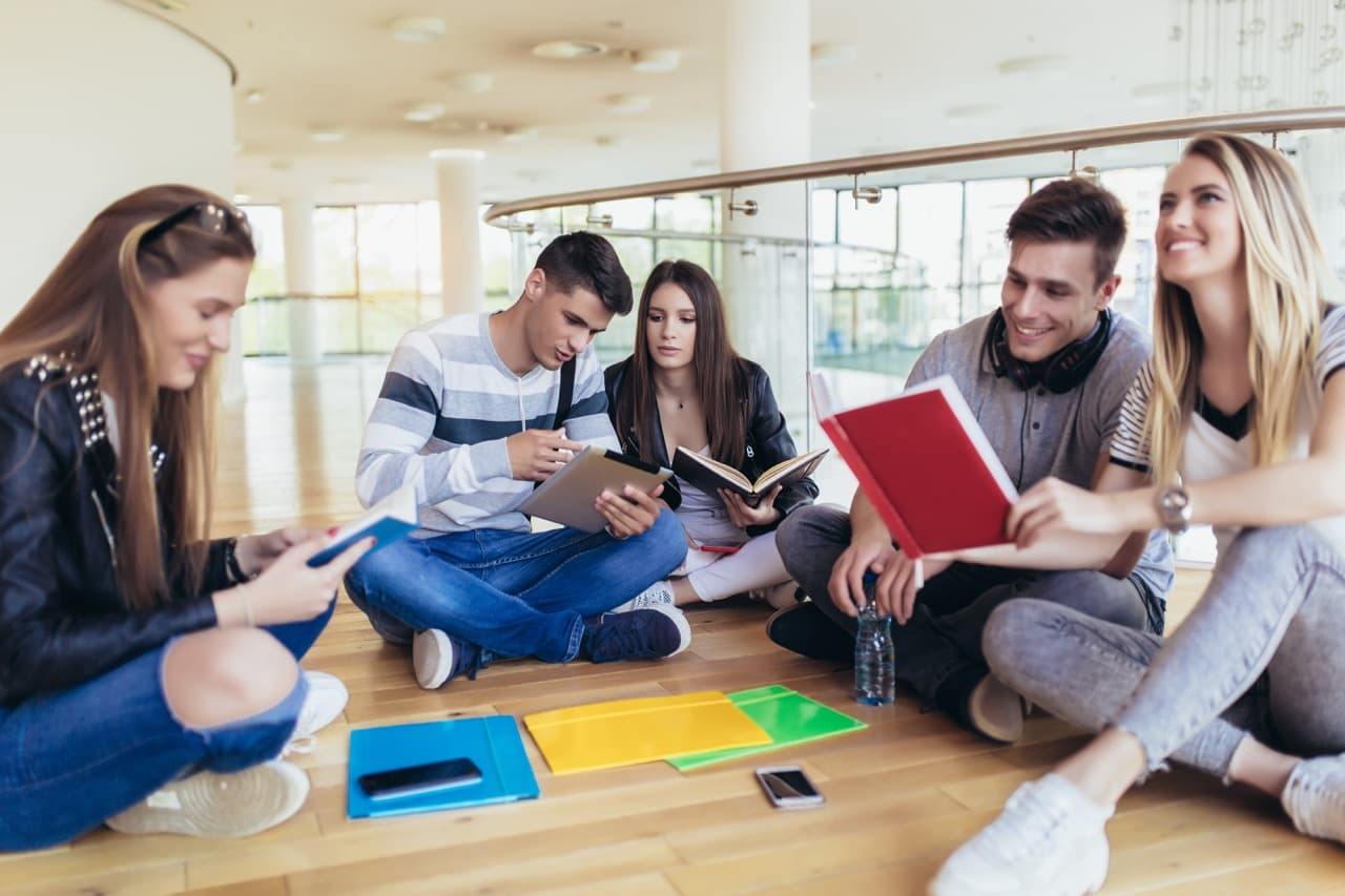 Fellow students sitting together on campus, preparing for exams