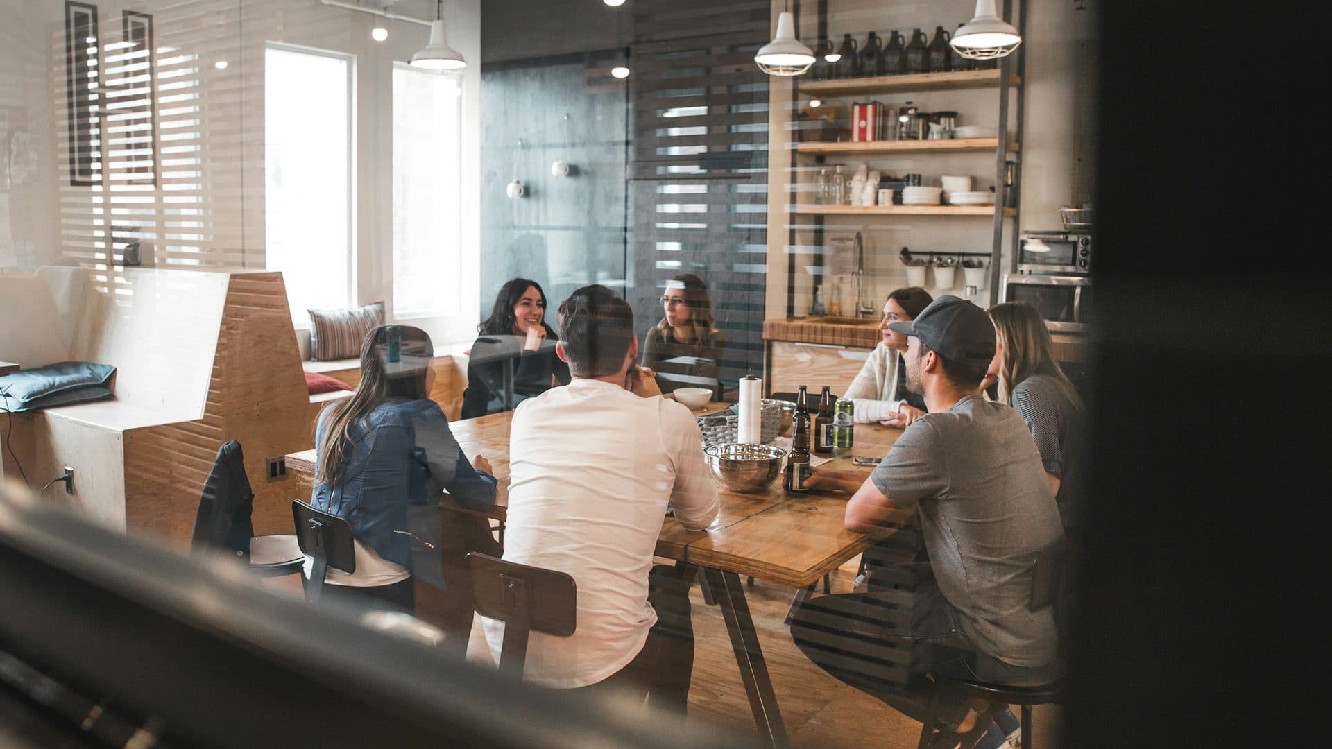 A team meeting around a table with laptops and notes